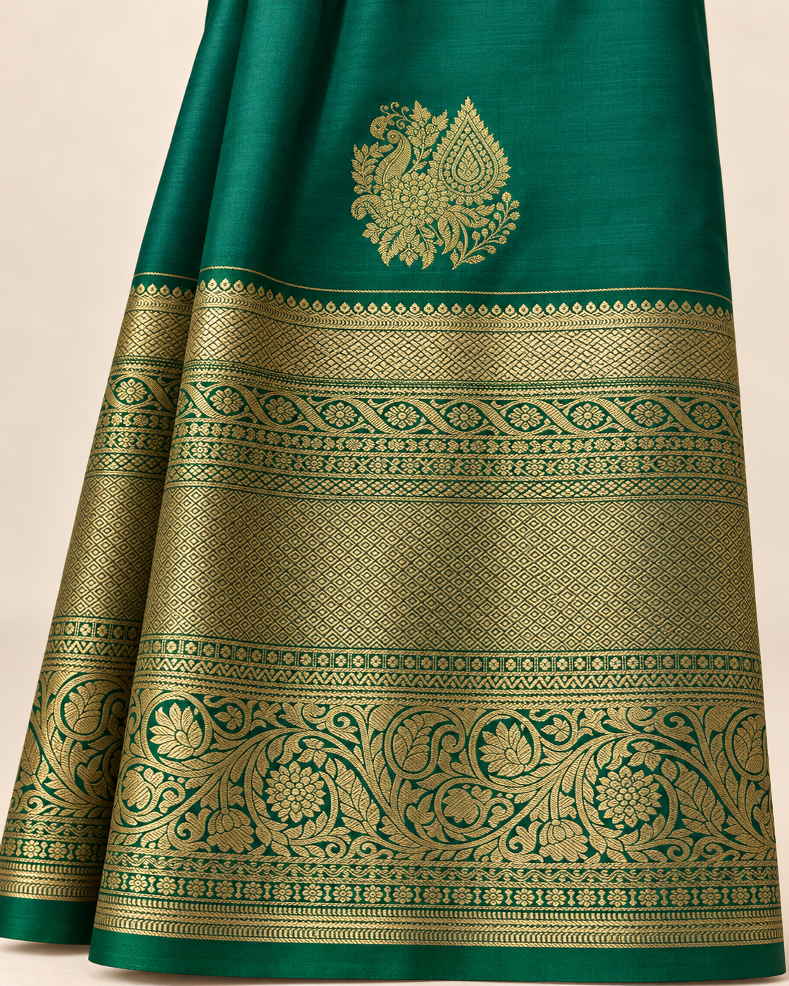 Close-up of the compact gold peacock and pointed paisley motif above the floral and geometric saree border.