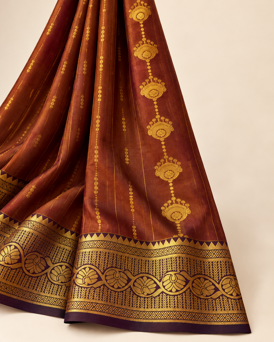 Detail of small gold-tone motifs and aubergine and gold-tone saree border