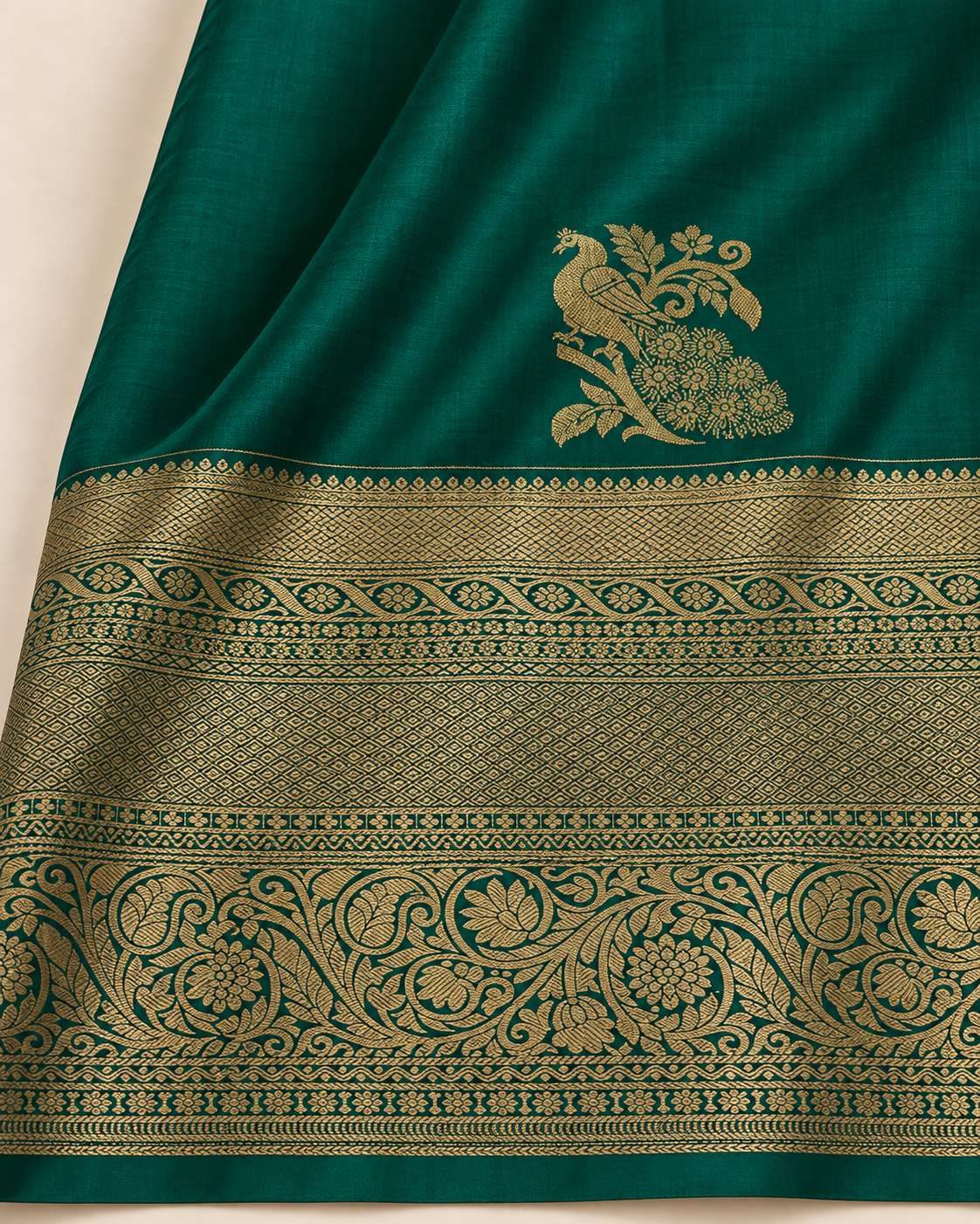Close-up of the gold peacock motif and floral and geometric border on green silk.