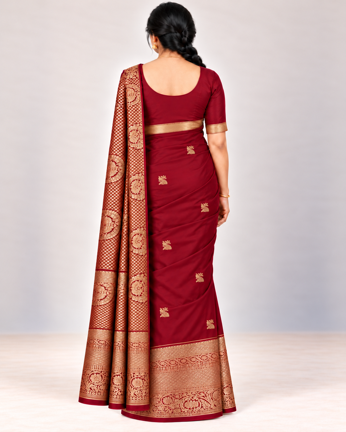Rear view of the wine red silk saree with staggered gold peacock motifs and patterned pallu