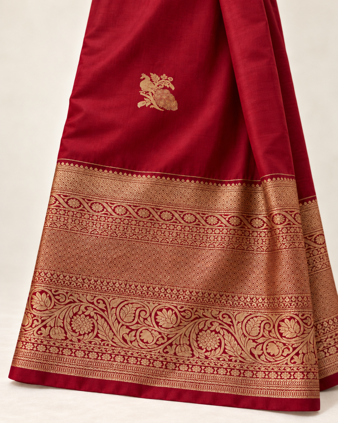 Close-up of a gold peacock motif and the ornate gold border on wine red silk